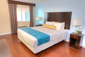 ein Schlafzimmer mit einem großen Bett und Holzboden in der Unterkunft Sunrise Inn San Diego in San Diego