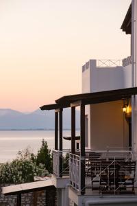 a house with a balcony with a view of the water at Villa Victoria by La Scala Beach in Limenas