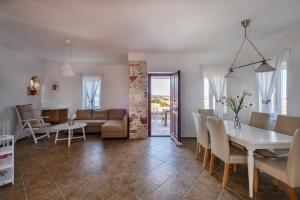 a living room and dining room with a table and chairs at Stone Villa Kontiani - Red Villa in Dhragoulás +13 photos