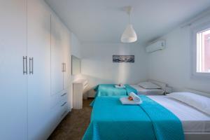 two beds in a white room with blue sheets at Stone Villa Kontiani - Red Villa in Dhragoulás
