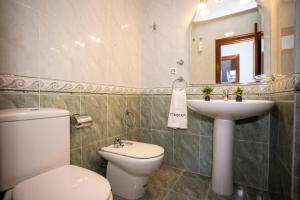 a bathroom with a white toilet and a sink at TuristiQA - Ático Ferrol Centro VUT-CO-02715 in Ferrol