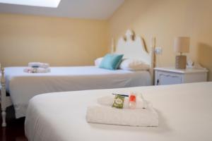 a hotel room with two beds with towels on them at TuristiQA - Ático Ferrol Centro VUT-CO-02715 in Ferrol