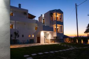 a large white building with a yard in front of it at Villa Victoria by La Scala Beach in Limenas