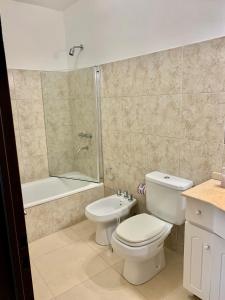 a bathroom with a toilet and a shower and a sink at Altos de Artusi in Concepción del Uruguay