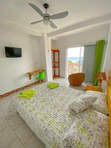 1 dormitorio con 1 cama y ventilador de techo en Whale House Hotel, en Puerto López