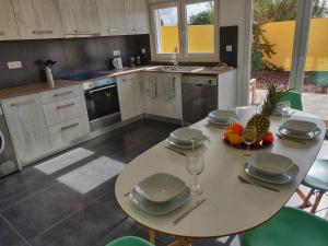 a kitchen with a table with plates and fruit on it at Olive Tree House in Ferrel