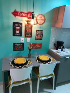 a kitchen with a table with two chairs and a counter at Magnífico Flat no melhor de Manaíra - Apart Hotel in João Pessoa