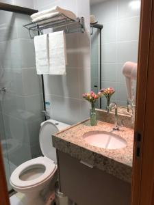 a bathroom with a toilet and a sink at Magnífico Flat no melhor de Manaíra - Apart Hotel in João Pessoa