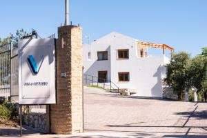 a sign in front of a white building at Villa Victoria by La Scala Beach in Limenas