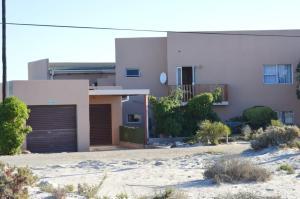 una casa bianca con un garage nel deserto di Khoinonia Guesthouse a Port Nolloth