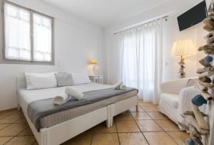 una camera bianca con un letto e una finestra di Santorini Mesotopos a Firà