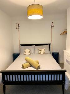 a bedroom with a bed with two yellow pillows on it at Holly Tree Cottage - 3 bedrooms and large garden with optional glamping double outside in Lymington