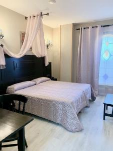 1 dormitorio con cama, mesa y cortinas en Hotel Castillo Bonavía, en Pedrola