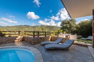 a patio with a swimming pool and two chairs at Villa Acquamarina semi detached villa with private pool and wifi in Torre delle Stelle