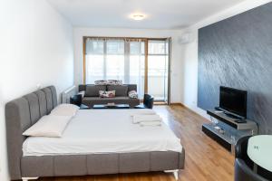 een slaapkamer met een groot bed en een bank bij Don Vito in Belgrado