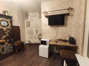 a kitchen with a table and a tv on a brick wall at Night in Magic Villins Book in Petrovo