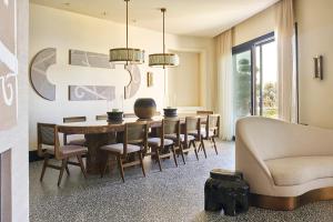 a dining room with a table and chairs and a couch at Root Redrock Yalıkavak in Yalıkavak