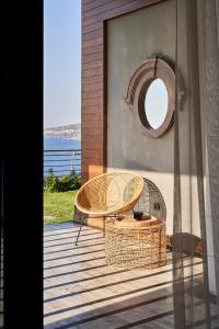 a wicker table and a mirror on a balcony at Root Redrock Yalıkavak in Yalıkavak