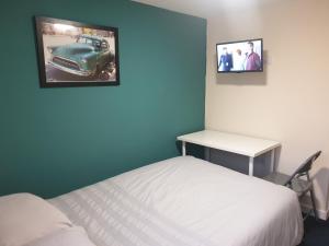 a bedroom with a bed and a picture of a car on the wall at Modern City Home with 5 Ensuites and Private Parking! Perfect for Working teams in Norwich