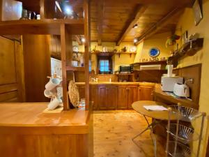 a large kitchen with wooden cabinets and a table at Pleta de Ordino 45B, Apartamento rústico para 6 personas. in Ordino