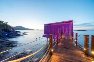 a purple building on a dock next to the water at Root Redrock Yalıkavak in Yalıkavak