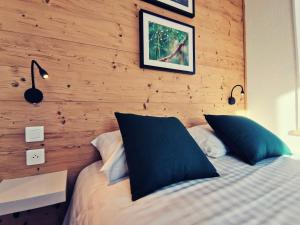 um quarto com uma cama e uma parede de madeira em Hotel Les Montagnards em Morteau