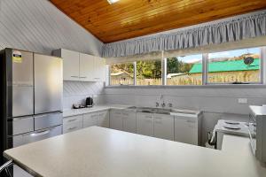 a kitchen with white appliances and a wooden ceiling at Gold Rush Inn in Queenstown