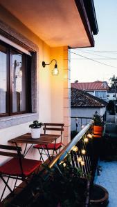 a patio with a table and chairs on a balcony at Casa das Flores in Santo Tirso