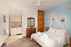 a bedroom with a white bed with towels on it at Villa Poseidon in Skala Eresou