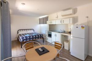 uma pequena cozinha com uma mesa e uma cama em Paringa Caravan Park em Renmark