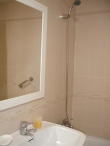 ein Bad mit einem Waschbecken und einer Dusche mit einem Spiegel in der Unterkunft Loix Mar - Zand Properties in Benidorm