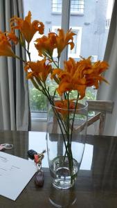 a vase filled with orange flowers on a table at Las Toscas Apart in Curuzú Cuatiá