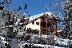 una casa en la nieve con árboles nevados en Residenze Sonnenschein Casa Rosa, en Villabassa