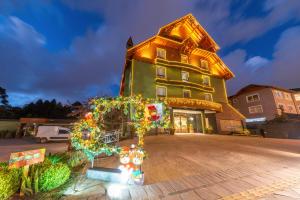 a house with christmas lights in front of it at Hotel Laghetto Viale in Gramado