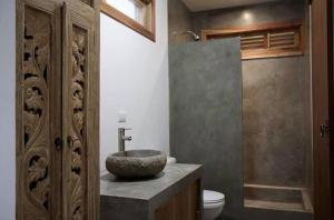 a bathroom with a stone sink and a toilet at Lucero in Santa Teresa Beach