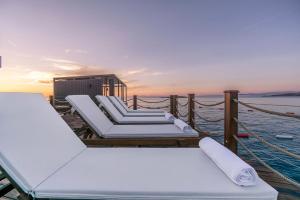 a group of lounge chairs on a dock with the ocean at Root Redrock Yalıkavak in Yalıkavak
