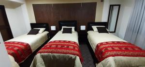 eine Gruppe von 3 Betten in einem Hotelzimmer in der Unterkunft Hostal Jerian in Uyuni