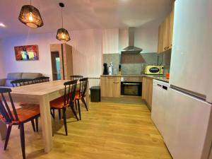 a kitchen with a table and chairs and a refrigerator at Ribasol 422, apartamento hasta 6 personas, Arinsal in Arinsal