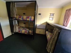 a room with two bunk beds in a room at Chateau Backpackers & Motels in Franz Josef