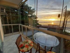 a balcony with a table and chairs and a view of the ocean at Apartamentos na Ponta dos Castelhanos - Anchieta in Anchieta