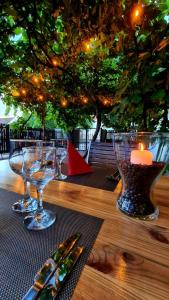 a wooden table with wine glasses and a candle on it at Hotel Crisana Arad in Arad