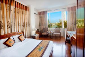 a bedroom with a bed and a view of a city at Bamboo Green Riverside Hotel in Danang