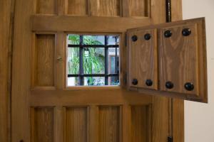 a wooden door with a window in it at La Sultana Apartamentos in Córdoba