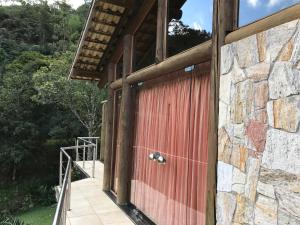 eine rote Tür an der Seite eines Gebäudes in der Unterkunft Pousada Rocamadour in Marechal Floriano