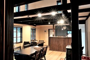 un comedor con mesas y sillas y un bar en Guest house kusunoki（women only） en Fukuyama