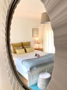 Schlafzimmer mit einem Bett und einem Spiegel in der Unterkunft SUITE LIKE SWEET in Torres Vedras