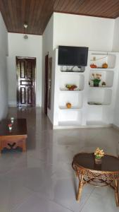 sala de estar con mesa y TV en la pared en Casa em Barra Grande - Maraú, en Barra Grande