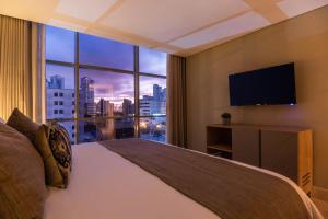 a bedroom with a large bed and a large window at Oz Hotel Luxury in Cartagena de Indias