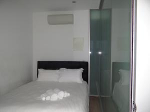 um quarto com uma cama com almofadas brancas e uma parede de vidro em Amazing Accommodations: Vogue em Melbourne
