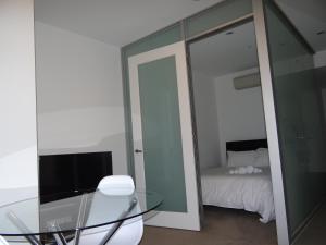 uma mesa de vidro e um espelho num quarto com uma cama em Amazing Accommodations: Vogue em Melbourne